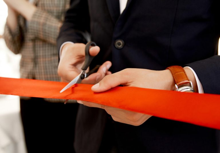 empresario cortando listón